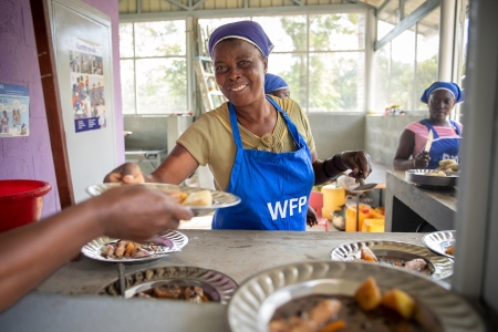 Lady serving school meals in Haiti 